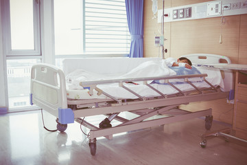 Asian boy lying on sickbed with saline intravenous (IV). Health care and people concept.