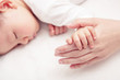 © DN6 - Hand the sleeping baby in the hand of mother close-up (Soft focu