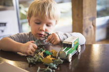 Caucasian Boy Playing With Toys On Table