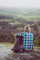 Wall Mural - Woman and her dog posing outdoor. Girl loving and hugging tightly her dog and watching landscape.