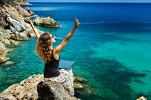 Woman Freelancer Feeling Happy With Laptop. Amazing Seaview With Blue Lagoon With Rocks. Happy Lady Is Raising Her Arms Up.