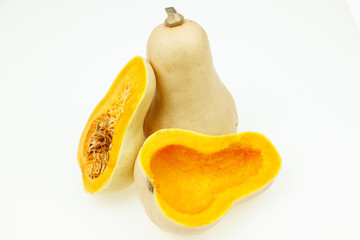 Wall Mural - Butternut squash fruits, one cut in half, on white background.