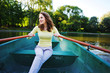 © raisondtre - amazing beautiful haired girl swims on a wooden boat and rowing with oars