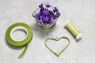 Wall Mural - Florist at work: steps of making viola odorata (violets) wreath