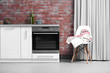 © Africa Studio - Modern kitchen furniture against brick wall background