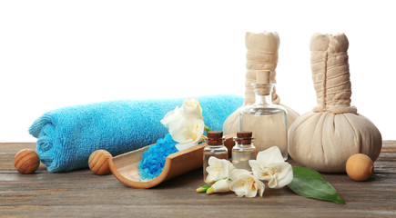 Wall Mural - Spa composition with sea salt in a bowl, massage balls and flowers on wooden table against white background