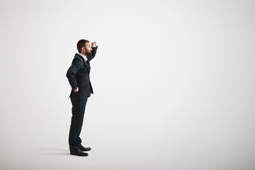 Wall Mural - A bearded man in a black business suit looks into the distance