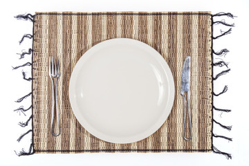 plate and cutlery on a single bamboo isolated on white backgroun