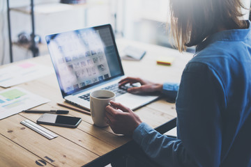 Working process modern office. Account manager working with new business project. Typing contemporary laptop, varios photo screen, on smartphone wood table. Horizontal. Film effect. Blurred background