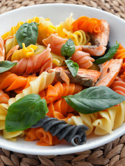 Canvas Print - Colorful fusilli pasta with baked salmon and basil. Vertical shot