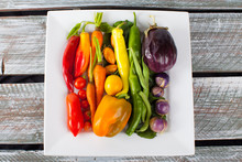 Platter Of A Rainbow Of Organic Freshly Harvested Vegetables On An Old Weathered Barn Wood Table