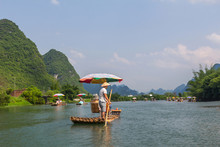 Bamboo Rafting In The Yulong River Surrounded By Dramatic Landsc