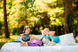 © SPY_studio - Two children, brother and sister having fun in a sunny summer garden with colorful pillows. Little girl and baby boy playing in park.