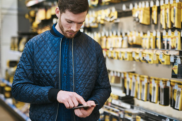 Young man checking a text message in a store