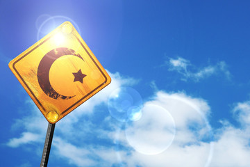 Yellow road sign with a blue sky and white clouds: Islam faith s