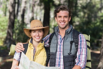 Wall Mural - Happy young couple with map during hiking 