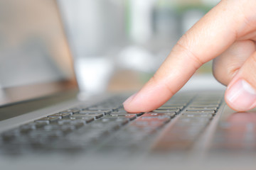 Closeup of business woman hand typing on laptop keyboard