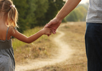 the parent holds the hand of a small child