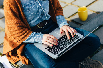 Wall Mural - Woman using laptop while sitting on cement stairs