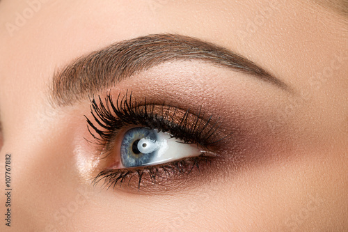Fotografering Close-up of woman eye with beautiful brown smokey eyes makeup