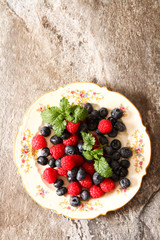 blueberries and raspberries on a plate ventazhnoy gray stone bac