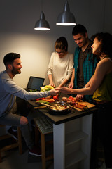 Wall Mural - Young group of friends preparing vegetable meal and making fun.