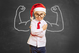 Fototapeta  - Kind als Weihnachtsmann mit Muskeln auf Tafel