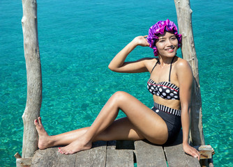 Wall Mural - woman in retro swimsuit posing on the mole over sea