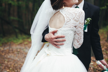 Tender groom's embracement in the forest