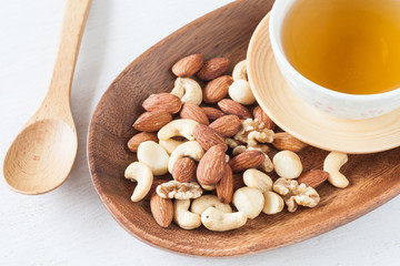 Canvas Print - Assorted mixed nuts , Almond , Cashews nuts , macadamia , walnut with hot chinese tea