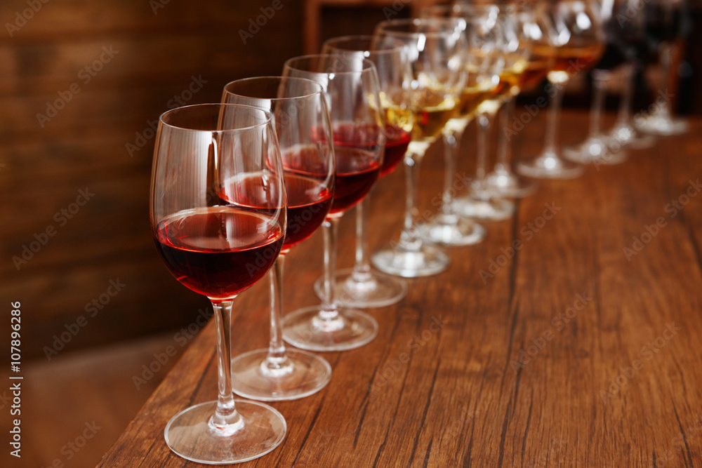 Many glasses of different wine in a row on bar counter