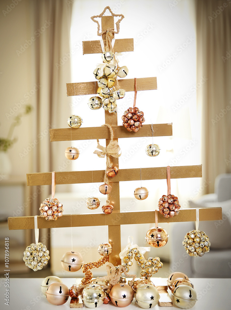 A handmade Christmas tree and baubles on the table in the room
