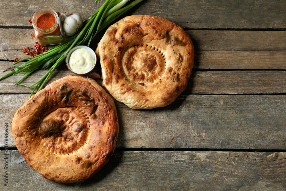 Fresh fried bread with other products on wooden background