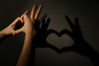 © Africa Studio - Hand shaped heart on dark background