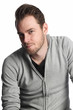 © _robbie_ - A man in his 20s wearing a grey shirt standing in front of a white background looking straight into camera.