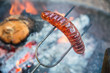 Preparing sausage on campfire 