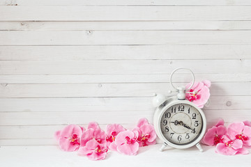 Poster - Background with white alarm clock and flowers pink orchid on whi