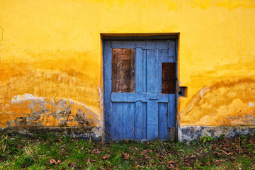 Old house blue door and yellow painted wall