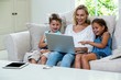 © WavebreakMediaMicro - Cheerful children and mother using laptop on sofa