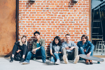 Group of young beautiful multiethnic friends sitting on the floo