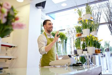 Canvas Print - florist man or seller at flower shop counter