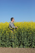 © sima - Farmer or agronomist in blossoming rapeseed field