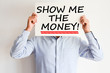 Show me the money text written on paper card suggesting employee success bonus payment