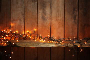 Wall Mural - Electric lighted garland on wooden background