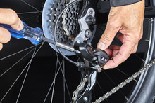 Man adjusting bicycle derailleur gear with tools Closeup