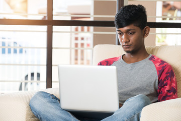 Indian male teenager using laptop