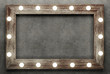 Wooden frame on concrete background illuminated by light bulbs. 3D rendering