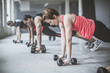 © John Fedele/Blend Images - Athletes doing push-ups with dumbbells on floor
