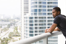 African American Man Standing On Urban Balcony