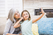 © Mike Kemp/Blend Images - Caucasian grandmother and granddaughter taking selfie with cell phone